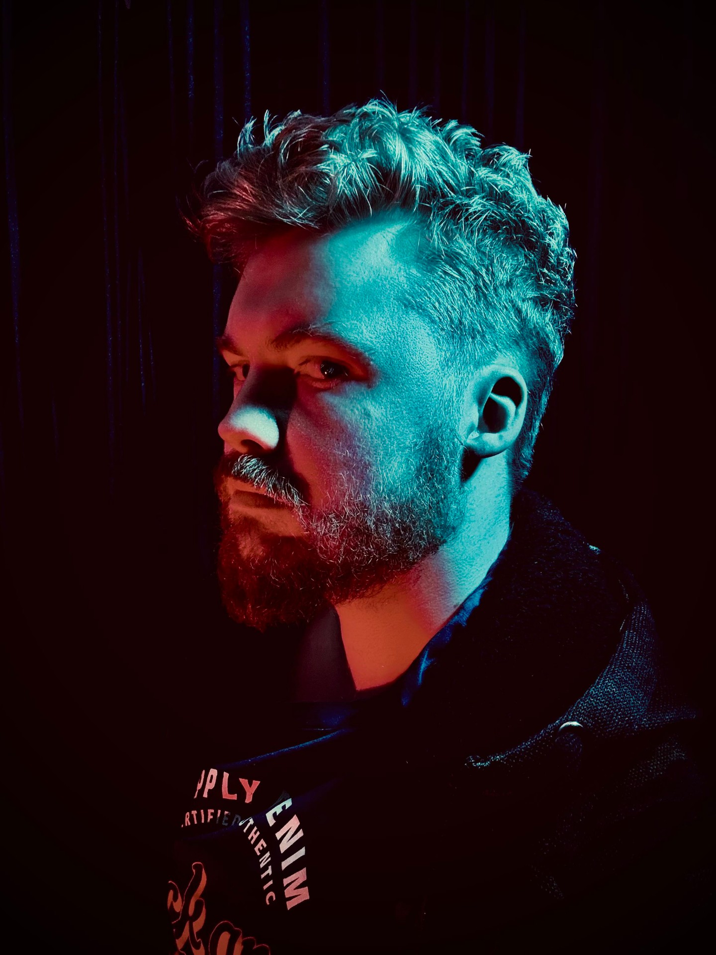 Connor Urquhart, founder of Granite Sites, portrait under neon lighting